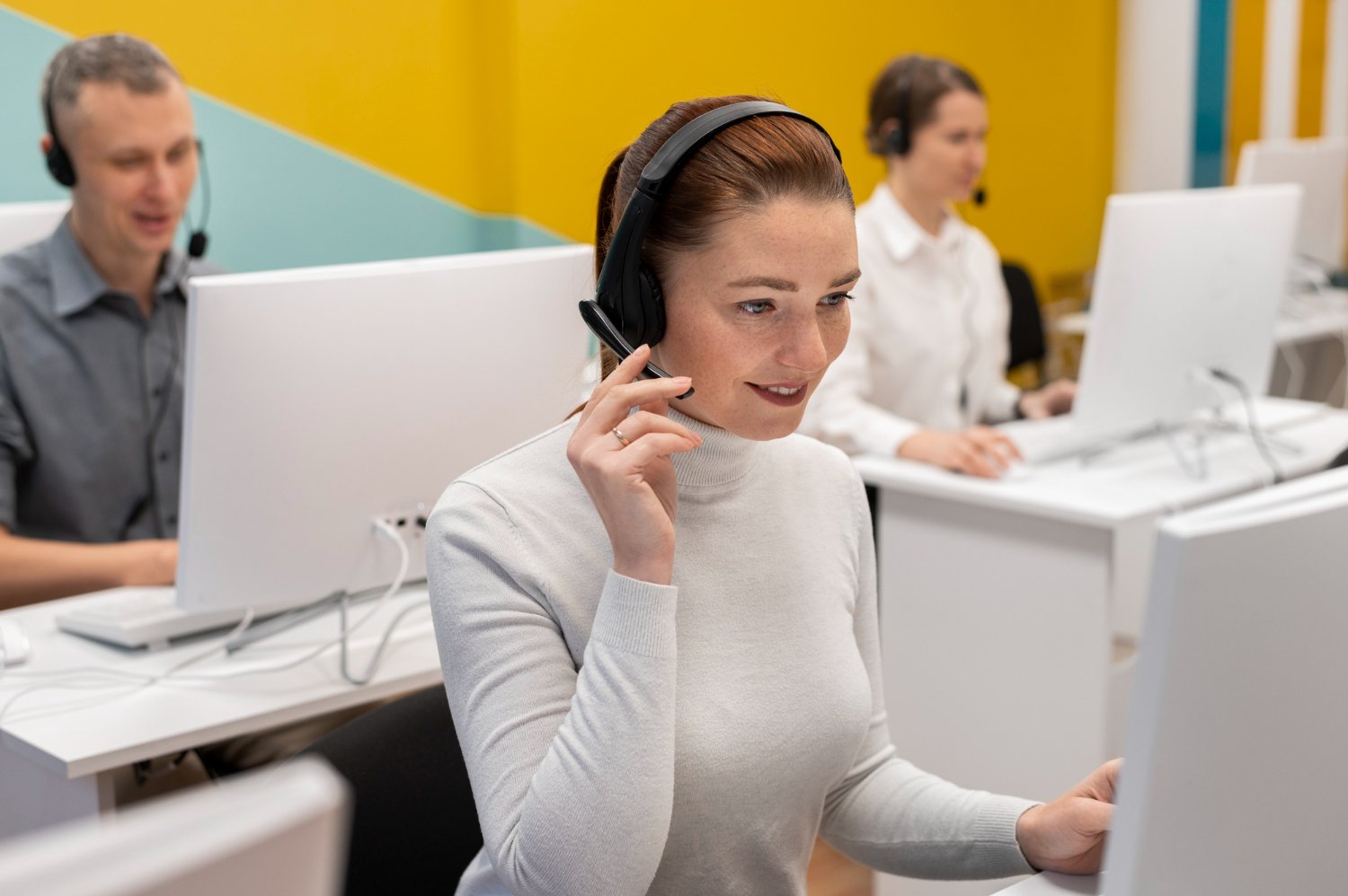 A team of professional call center agents providing customer support services through headsets and computers